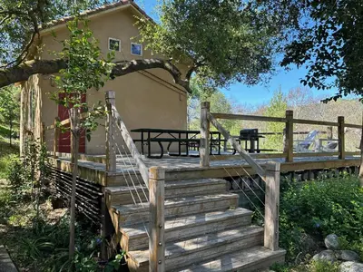 a wooden staircase leading up to a house with a tree at Sequoia River Front Cabins in Three Rivers