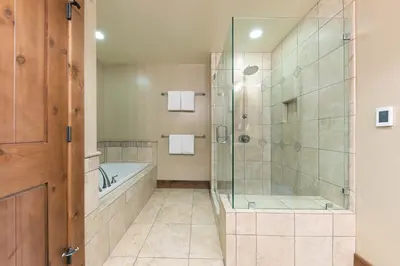 a bathroom with a tub and a glass shower at Big Horn Lodge 401 by East West Hospitality in Truckee