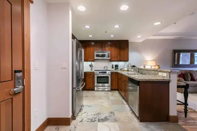 a kitchen with wooden cabinets and stainless steel appliances at Big Horn Lodge 409 by East West Hospitality in Truckee