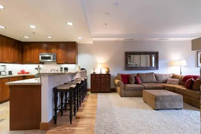 a living room with a couch and a kitchen at Big Horn Lodge 409 by East West Hospitality in Truckee