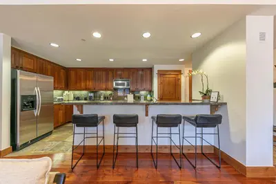 a kitchen with a island with bar stools at Big Horn Lodge 404 by East West Hospitality in Truckee