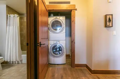 a laundry room with a washer and dryer in it at Big Horn Lodge 501 by East West Hospitality in Truckee