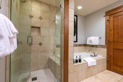 a bathroom with a shower and a tub and a sink at Big Horn Lodge 501 by East West Hospitality in Truckee