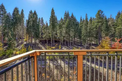 a balcony with a view of a forest of trees at Big Horn Lodge 510 by East West Hospitality in Truckee