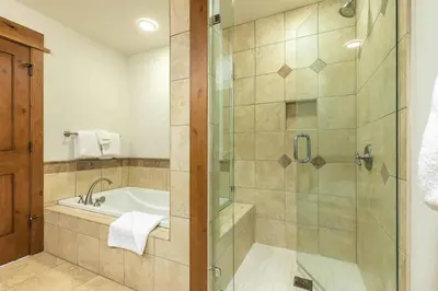a bathroom with a shower and a bath tub at Big Horn Lodge 410 by East West Hospitality in Truckee