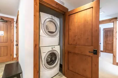 a washer and dryer in a room with a door at Big Horn Lodge 410 by East West Hospitality in Truckee