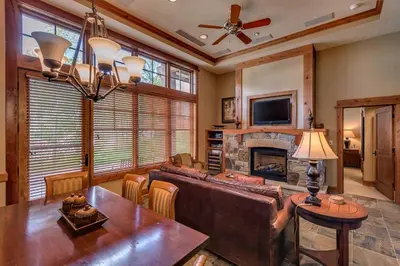 a living room with a couch and a table and a fireplace at Catamount Lodge 103B by East West Hospitality in Truckee