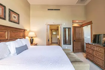 a bedroom with a large bed and a television at Catamount Lodge 103B by East West Hospitality in Truckee