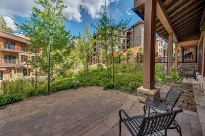 two benches sitting on a patio in a yard at Catamount Lodge 103B by East West Hospitality in Truckee