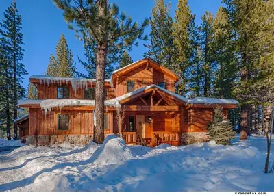 a log cabin in the woods in the snow at Caleb Drive 12802 by East West Hospitality in Truckee