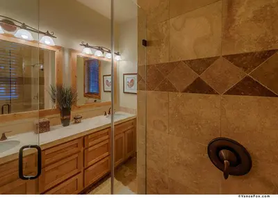 a bathroom with a shower and a sink and a mirror at Caleb Drive 12802 by East West Hospitality in Truckee