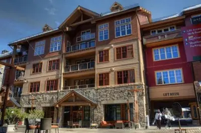a large building with people walking in front of it at Catamount Lodge 103A by East West Hospitality in Truckee