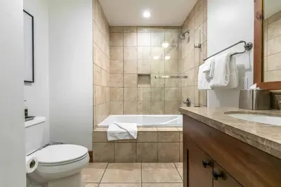 a bathroom with a tub and a toilet and a sink at Catamount Lodge 105 by East West Hospitality in Truckee