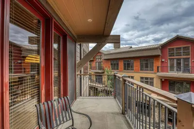a balcony with a bench and some buildings at Catamount Lodge 201B by East West Hospitality in Truckee