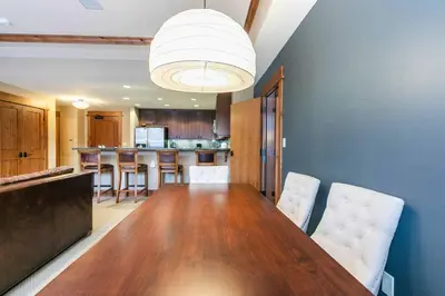 a kitchen with a long wooden table and chairs at Catamount Lodge 201 by East West Hospitality in Truckee