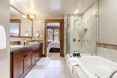 a bathroom with a tub and a shower and a sink at Catamount Lodge 201 by East West Hospitality in Truckee