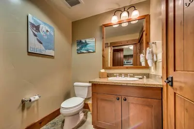 a bathroom with a toilet and a sink and a mirror at Catamount Lodge 204B by East West Hospitality in Truckee