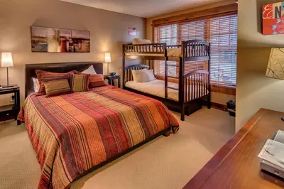 a bedroom with a bed and a bunk bed at Catamount Lodge 204B by East West Hospitality in Truckee
