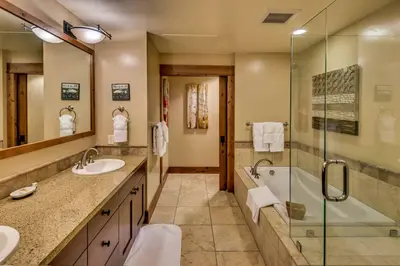 a bathroom with two sinks and a shower at Catamount Lodge 204B by East West Hospitality in Truckee