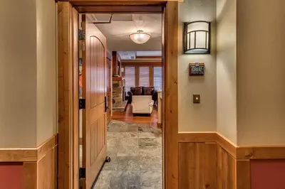 a hallway with a door leading to a living room at Catamount Lodge 204B by East West Hospitality in Truckee