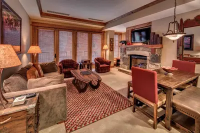 a living room with a couch and a fireplace at Catamount Lodge 211 by East West Hospitality in Truckee