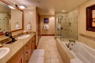 a bathroom with two sinks and a tub and a shower at Catamount Lodge 211 by East West Hospitality in Truckee