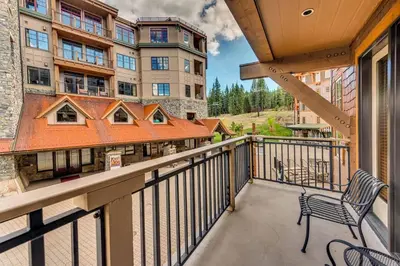 a balcony with a bench and a building at Catamount Lodge 211 by East West Hospitality in Truckee