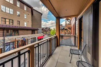 a balcony with a chair and a building at Catamount Lodge 206B by East West Hospitality in Truckee