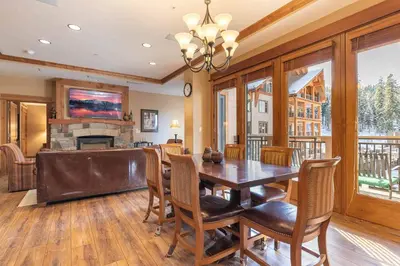 a dining room with a table and chairs and a fireplace at Catamount Lodge 308 by East West Hospitality in Truckee