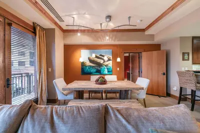 a dining room with a table and a couch at Catamount Lodge 305 by East West Hospitality in Truckee