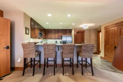 a kitchen with a island with bar stools at Catamount Lodge 305 by East West Hospitality in Truckee