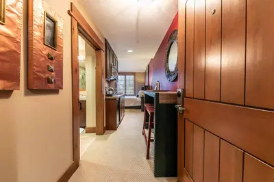 a hallway with a door leading to a kitchen at Catamount Lodge 305 by East West Hospitality in Truckee