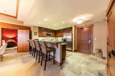 a kitchen with a island with bar stools at Catamount Lodge 305B by East West Hospitality in Truckee