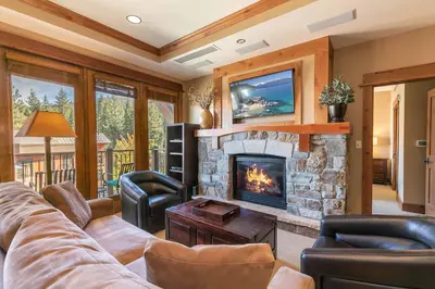 a living room with a couch and a fireplace at Catamount Lodge 301 by East West Hospitality in Truckee