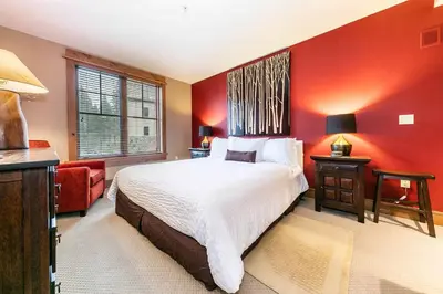 a red bedroom with a bed and a red wall at Catamount Lodge 305A by East West Hospitality in Truckee