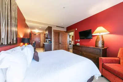 a bedroom with a white bed and a red wall at Catamount Lodge 305A by East West Hospitality in Truckee