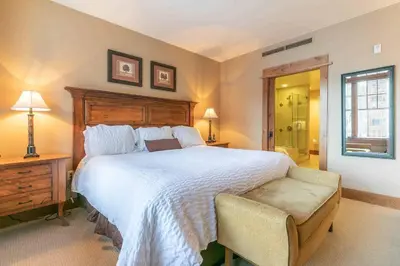 a bedroom with a large bed and a chair at Catamount Lodge 312 by East West Hospitality in Truckee