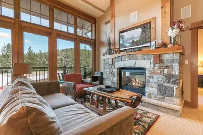 a living room with a couch and a fireplace at Catamount Lodge 401 by East West Hospitality in Truckee