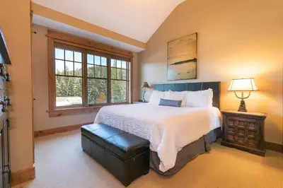 a bedroom with a large bed and a window at Catamount Lodge 401 by East West Hospitality in Truckee