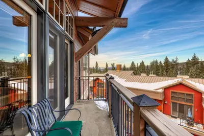 a balcony of a house with a bench on it at Catamount Lodge 401B by East West Hospitality in Truckee