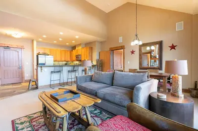 a living room with a couch and a table at Catamount Lodge 401B by East West Hospitality in Truckee