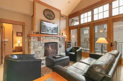 a living room with a couch and a fireplace at Catamount Lodge 404B by East West Hospitality in Truckee
