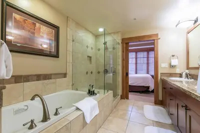 a bathroom with a tub and a shower and a sink at Catamount Lodge 404B by East West Hospitality in Truckee