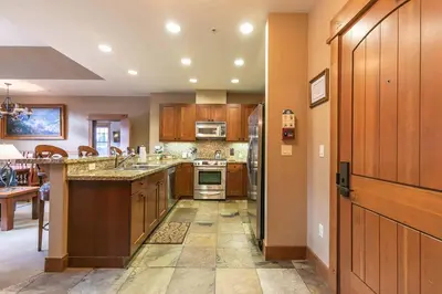 a large kitchen with wooden cabinets and appliances at Catamount Lodge 404B by East West Hospitality in Truckee