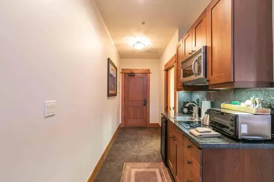 a kitchen with wooden cabinets and a counter top at Catamount Lodge 405A by East West Hospitality in Truckee