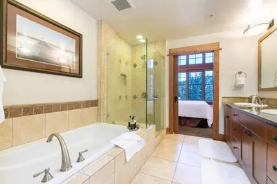 a bathroom with a tub and a shower and a sink at Catamount Lodge 405B by East West Hospitality in Truckee