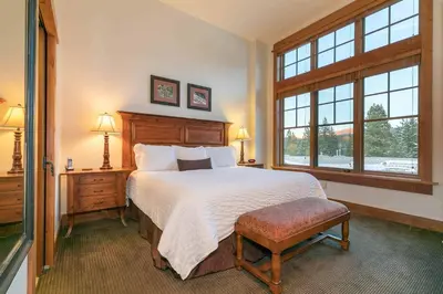 a bedroom with a large bed and a window at Catamount Lodge 405B by East West Hospitality in Truckee