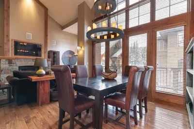 a dining room with a wooden table and chairs at Catamount Lodge 408 by East West Hospitality in Truckee