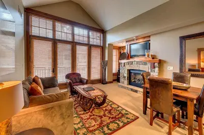 a living room with a couch and a fireplace at Catamount Lodge 411 by East West Hospitality in Truckee