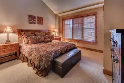 a bedroom with a large bed and a window at Catamount Lodge 411 by East West Hospitality in Truckee
